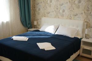 莫斯科Apartment on Smolnaya 44/1的一间卧室配有蓝色的床和2条毛巾