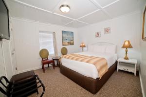 泰比岛Georgianne Inn & Suites check in 212 Butler Ave的卧室配有一张床和一张桌子及椅子
