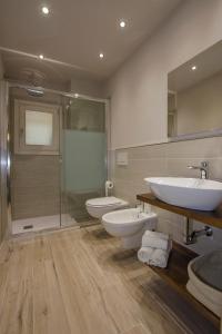 蒙泰斯佩尔托利Poggio al Sole的一间带两个盥洗盆、淋浴和卫生间的浴室