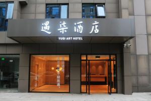 杭州Hangzhou Yuqi Hotel - West Lake Leifeng Tower Branch的一座建筑,上面有写着读取你艺术酒店的标志