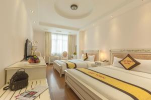 胡志明市坎普镇酒店的酒店客房设有两张床和电视。
