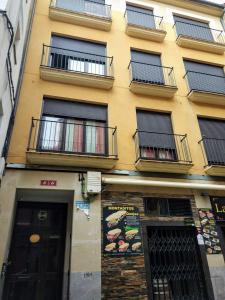 洛格罗尼奥Los Tejados de Laurel的黄色的建筑,旁边设有阳台