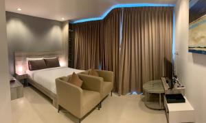 梅尔皮姆Grandblue Condominium#702 Seaview TopFloor MaePim Rayong的一间卧室配有一张床、一张沙发和一把椅子