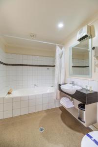 汉默温泉汉默斯普林斯汽车旅馆的带浴缸、水槽和镜子的浴室