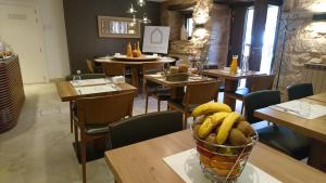Valgañón普拉维达酒店 的一间设有桌椅和一碗香蕉的餐厅