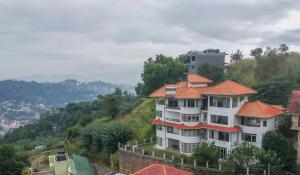 康提The Heaven's Villa Kandy的一座白色的大建筑,有橙色的屋顶