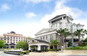 新竹烟波大饭店新竹湖滨馆 的一座白色的大建筑,前面有棕榈树