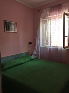 维耶斯泰Villa Carla的一间卧室设有一张绿色的床和一个窗户。