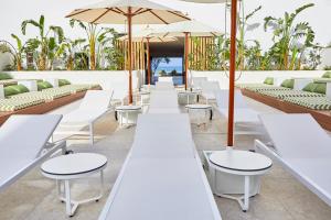 帕尔马海滩杜纳斯布兰卡斯HM酒店的一排带遮阳伞的白色桌椅