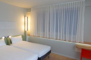 布拉加布拉加中心宜必思快捷酒店的客房设有两张床和窗户。