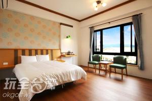 鹿谷乡豆田町的一间卧室配有一张床、一张书桌和一个窗户。