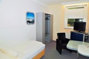 汉堡库克皮特酒店的客房设有1张床、1张桌子和1台电视。