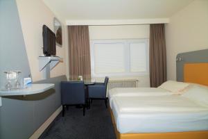 汉堡库克皮特酒店的配有一张床、一张桌子和一张桌子的酒店客房