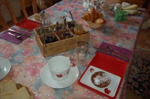 Francueil罂粟花住宿加早餐酒店的餐桌,桌上放着一盘面包,一杯咖啡和糕点