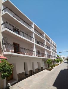 圣埃乌拉利亚萨罗塔旅馆的白色的公寓楼,位于街道上,设有阳台