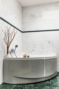 莱茵河畔威尔Dreamapartment La Vigna Suite mit eigenem Indoorpool & Sauna - Weil am Rhein的浴室铺有白色瓷砖,配有白色浴缸。