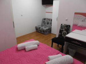 弗拉涅Prenociste Bojan 017的配有粉红色床铺和两个枕头的房间