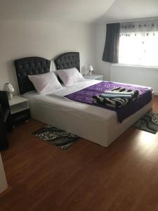 弗拉涅Prenociste Bojan 017的一间卧室配有一张带紫色床单的床和窗户。