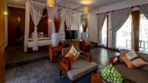 暹粒拉里维耶尔蒂吴哥度假酒店的酒店客房设有床和客厅。