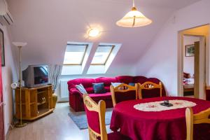豪伊杜索博斯洛Kis-Gast Panoráma Apartman的客厅配有红色的沙发和桌子