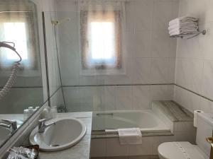 托米尼奥努埃瓦科利纳酒店的白色的浴室设有浴缸和水槽。