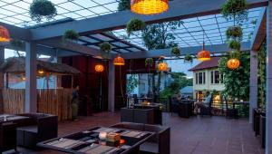 暹粒拉里维耶尔蒂吴哥度假酒店的餐厅设有橙色灯光和桌子,背景人员