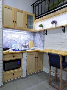 斯雷姆斯卡米特罗维察Apartmani Sirmium的一个带木制橱柜和水槽的厨房
