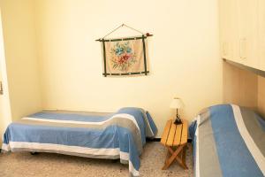 亚历山德里亚Casa Abba的一间卧室配有两张床和一张带台灯的桌子