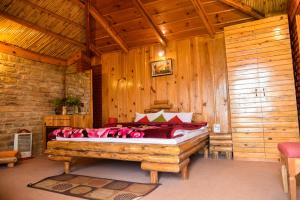 穆克缇斯瓦Trinetra Orchards的木制客房内的一间卧室,配有一张床