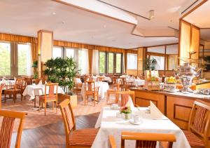 柏林斯坦格利兹国际酒店的餐厅设有白色的桌椅和窗户。