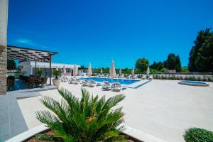 乌尔齐尼Hotel Ambiente Ulcinj的一个带躺椅和遮阳伞的游泳池