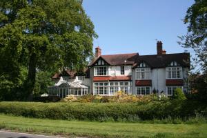 伍尔弗汉普顿The Round House at Boningale Manor的坐在路边的白色和红色大房子