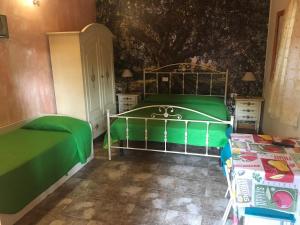 维耶斯泰B&B Villa Carla的一间卧室配有一张绿色的床和一张桌子