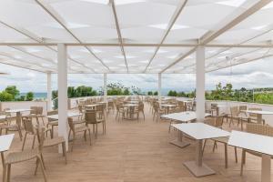 莫诺波利Torre Cintola Greenblu Sea Emotions的屋顶上设有桌椅的空餐厅