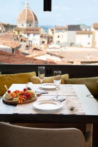 佛罗伦萨迪格里奥拉费酒店的一张桌子,上面放着一盘食物和酒杯