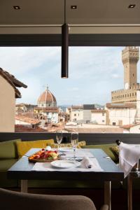 佛罗伦萨迪格里奥拉费酒店的一张桌子,上面放着一盘食物和酒杯