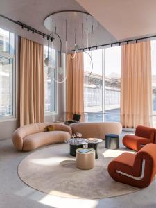 巴黎OKKO Hotels Paris Gare de l'Est的带沙发和桌子的客厅以及窗户。