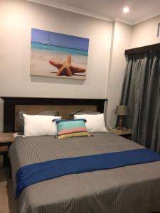 巴利托Ballito Bay Holiday Apartment的卧室配有一张墙上有海星的床