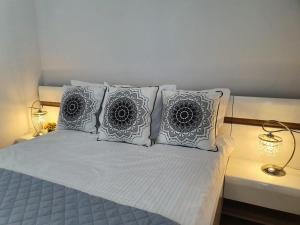 尤斯托尼莫斯基Sailor- Z WIDOKIEM NA MORZE- 365PAM的一张带四个枕头的床和两盏灯