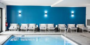 香槟沙隆Armes de Champagne的一个带椅子和蓝色墙壁的等候室的游泳池