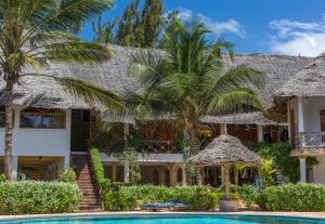 普瓦尼梅查恩加尼AHG Waridi Beach Resort & SPA的一座带游泳池和棕榈树的房子