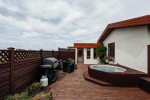 SandgerðiComfort and Rest的房屋顶部带热水浴池的甲板