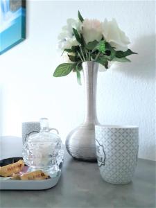 圣路易Comfort Stay Basel Airport 1A46的花瓶,坐在桌子上