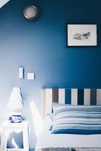 迪纳尔克洛斯恩豪特住宿加早餐式酒店的一间卧室设有蓝色的墙壁、一张床和一张桌子