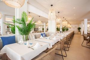 卡兰博希阿尔迪卡兰博斯格如波酒店公寓的餐厅设有白色的桌椅和吊灯。