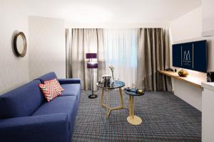 布雷根茨Grand Hotel Bregenz - MGallery Hotel Collection的客厅配有蓝色的沙发和桌子
