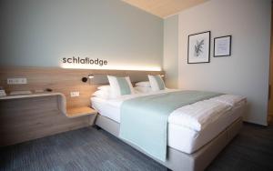 多瑙河畔伊布斯Donau Lodge的一间卧室,配有一张床和一个读精神分裂症的标志