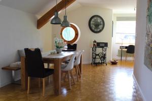 ChalampéGroßzügige helle Ferienwohnung bis 4 Personen in Chalampe, Elsass的一间带桌椅和时钟的用餐室