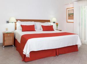 比亚埃尔莫萨维瓦维拉尔莫萨酒店的一间卧室配有一张带红色枕头的大床