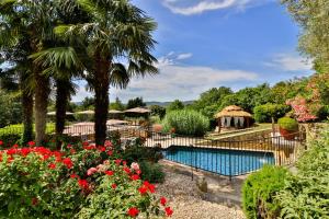 卢马罕乐马斯德拉萨伦巴德酒店的花园内的游泳池,花园内种有鲜花,设有凉亭